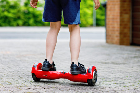 Close-up of kid boy on hover board. Child driving modern balance hoverboard. Excercise and sports...