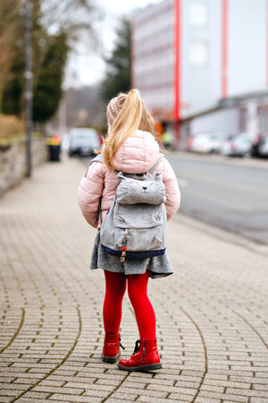 Cute little preschool girl going to playschool. Healthy toddler child walking to nursery school and...