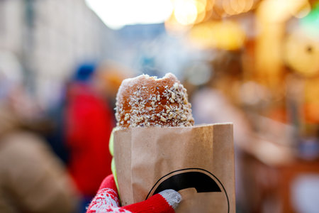Woman holding Baumstriezel, trdelnik or kurtoscalacs on German traditional Christmas marketの写真素材