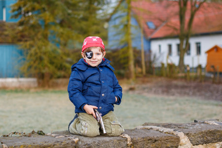 Little preschool boy of 4 years in pirate costume, outdoors. Happy child celebrating carnival called Fasching in Germanの写真素材
