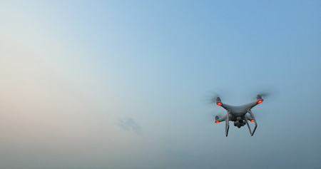 Drone with camera flies overhead in the blue evening skyの写真素材
