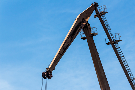 Arrow of an old rusty port crane close-up against a sky background.の写真素材