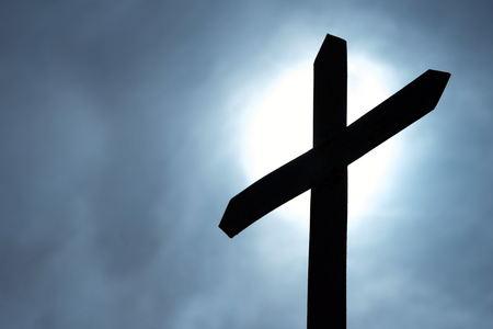 Silhouette of the Catholic cross during the full moon against the background of the dark sky.の写真素材