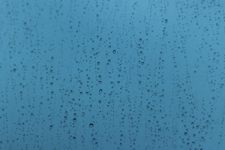 Drops of rain water of different sizes on the window.