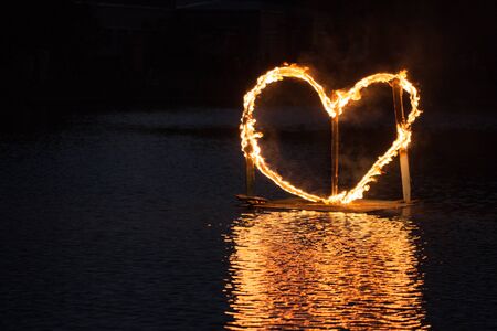 A fiery heart floats on the water.の写真素材