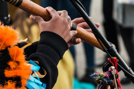 The hands of a street musician in a suit on an ethnic musical wind instrument made of bamboo.の写真素材