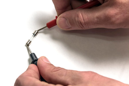 The man tests the integrity of the fuse. Hands close-up.