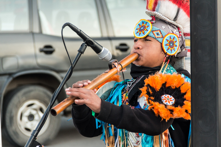 KAZAKHSTAN, Kostanay, September, 2017. A street musician in Indian costume plays on a self-made pipe made of bamboo.のeditorial素材