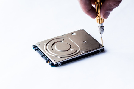 Repair of hard disk for laptop. The computer master wipes the screw with a screwdriver.の写真素材