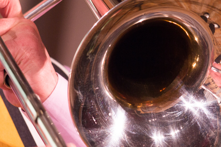 Wind musical instrument in the hands of a musician. Trombone close-up.の写真素材