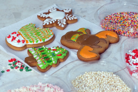 New Year Treats. Four gingerbread and confectionery decorations. Handmade cookies in the form of a mitten, a Christmas tree, a snowman and a snowflake.の写真素材