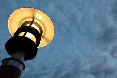 Yellow bright street lamp against the background of the evening or morning sky with clouds.の写真素材