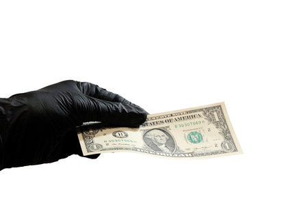 The left hand in a black rubber glove holds one US dollar. Copyspace. Isolated on white background.の写真素材