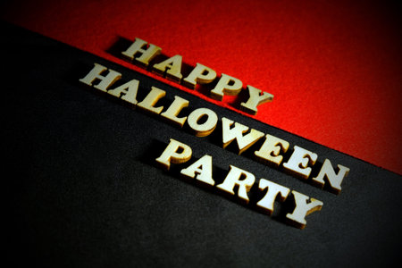 Inscription HAPPY HALLOWEEN PARTY made of wooden letters on a black-and-red background. Copy space. Vignetting.の写真素材