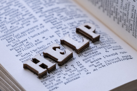 English-Russian dictionary. The word HELP from wooden letters is laid out on the page of the book.Close-up, shallow depth of field, noise. Concept of learning a foreign language, preparing students for exams.の写真素材