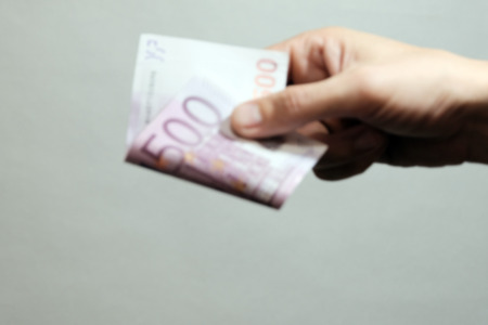 Blurred. Banknote of five hundred euros in the right male hand. Background for design on the theme of corruption in medicine, science or forensics. Copy space.の写真素材