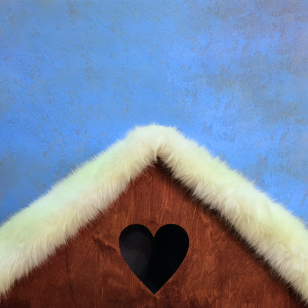 Decorative roof of the house with a hole in the shape of a heart. Theme for New Year, Christmas or Valentine's Day design. Square frame Blue background.の写真素材