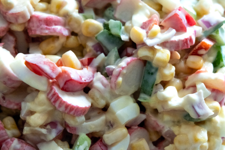 Background of vegetable salad Olivier or with crab sticks. Ingredients with mayonnaise. The concept of cooking in a cafe or at home and preparing for the holiday table.の写真素材