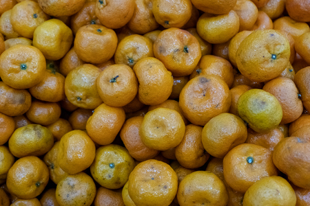 Background of bad citrus in the store. Spoiled tangerines. Rotting fruit goods at the grocery store.の写真素材