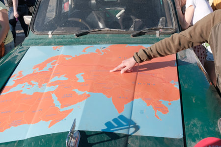 Kazakhstan, Kostanay, 19-06-19, Map of Eurasia on the hood of an old car. The hand of the guy...