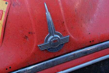 Kazakhstan, Kostanay, 19-06-19, The emblem of a vintage car Morris. Rally Peking to Paris. Close-up front of a red retro car. Dirt and stains from broken insects.のeditorial素材