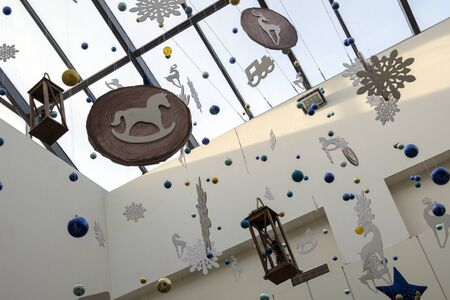 Decoration of the trading floor of the supermarket in the New Year style. Preparing for Christmas. Toys hang on threads under the ceiling. Festive background.の写真素材