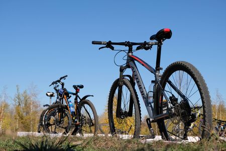 Kostanay, Kazakhstan, 2019-10-06. Autumn. Bike ride. Parking bicycles of different brands in nature. Blue sky Copy spaceのeditorial素材