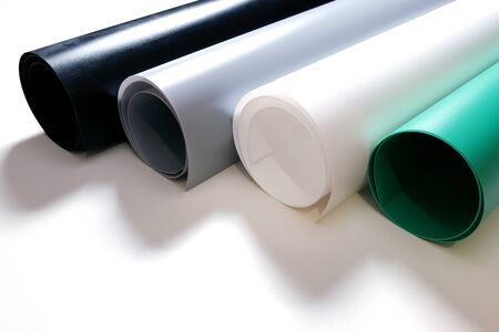Four rolls of PVC Matte Reflective Dual Side Photography Backdrop Background Paper. Black, gray, white and green colors.の写真素材