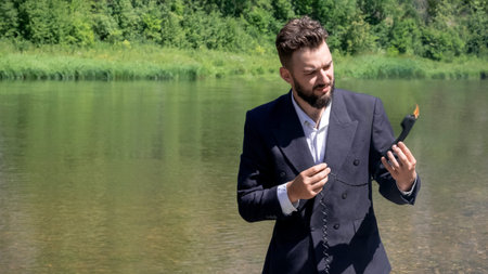 A businessman in a suit during vacation holds in his hand a handset that is on fire. The concept of...
