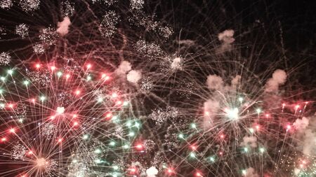 Sparkling red green yellow celebration fireworks over starry sky. Independence Day, 4th of July, New Year holidays salute background.の写真素材