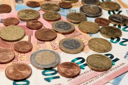 European money. Coins are on euro banknotes. Financial background. The concept of wealth, poverty, crisis, accumulation or success.の写真素材