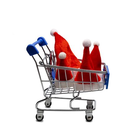 Four Santa Claus hats in a shopping trolley. The concept of a family consumer basket or Christmas shopping, seasonal Christmas sale. Advertising object. Close-up. Isolated.の写真素材