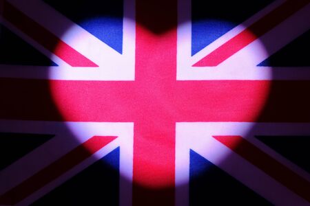 Heart made of light on the flag of Great Britain. The concept of European independence and the celebration of Valentine's Day. A symbol of patriotism, love and freedom in Europe. Dark background.の写真素材