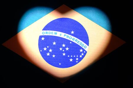 Brazil flag in the shape of a heart. Valentine's Day. The concept of love, patriotism and independence. Country symbol for design and illustration of relationships and feelings.Dark background.の写真素材