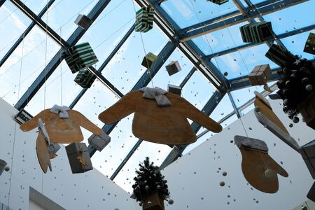 New Year's toys hang from the ceiling. Abstract festive Christmas decoration in a supermarket, airport, store, shopping center. Winter holiday mood. Background for the design of seasonal discounts and sales.の写真素材