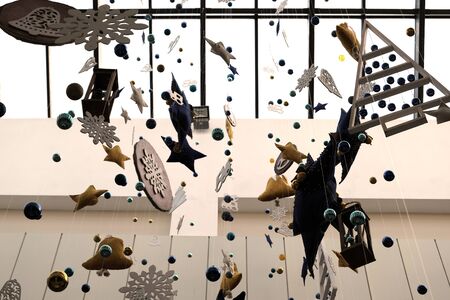 New Year decorations in a public place, supermarket, airport or shopping center. Toys hang from the ceiling. Background for the design of seasonal discounts and sales. Winter Christmas holiday mood.の写真素材