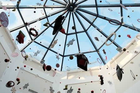 New Year's toys hang from the ceiling. Abstract festive Christmas decoration in a supermarket, clothing store, shopping center. Winter holiday mood. Background for the design of seasonal discounts and sales.の写真素材