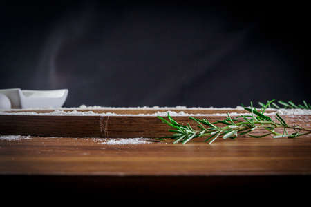 Wooden pizza pan, wrapped in wheat, eggs and rosemary. Front view.の写真素材