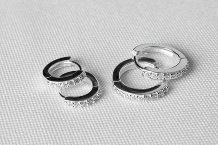 Elegant silver earring jewelry with precious stones, on white background. Two pairs.の写真素材