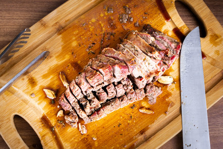 FLANK STEAK beef BBQ food. Roasted meat with potatoes and thyme on a wooden board, completely cut into slices. Top view.の写真素材