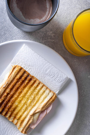 Grilled ham and cheese. Sandwich with cheese and ham on the grill. Served with coffee with milk and...