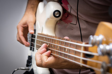White electric bass in musical solo, showing in detail the string being plucked.