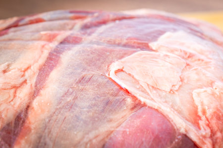 Whole raw sirloin steak on a wooden board, on a wooden table. Close view.の写真素材