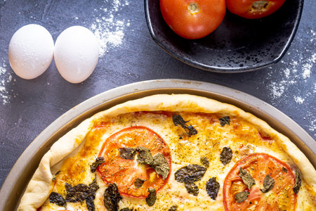 Delicious margherita pizza with basil, garlic, tomatoes, eggs. On black background. Top view.