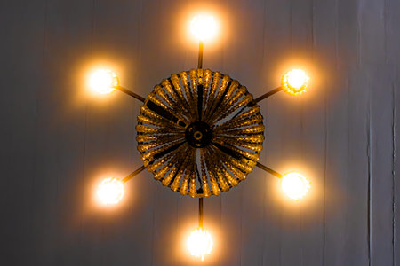 Ceiling chandelier in Convento da Penha with yellow lights and white background.