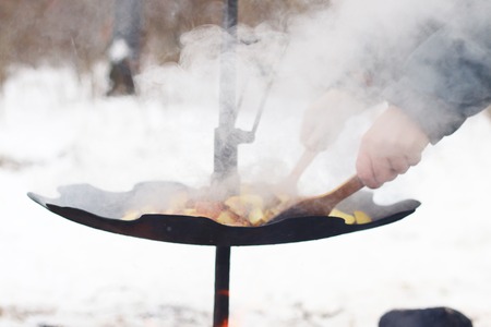 Frying raw potato in sunflower oil on big pan. Cooking potatoesの写真素材