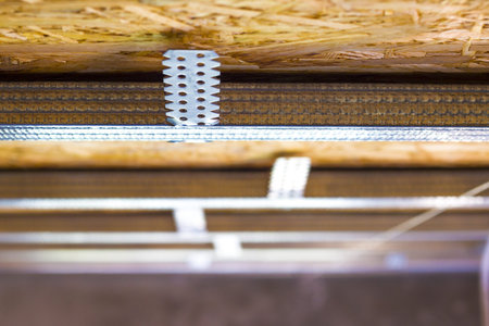Drywall mounting profile on chipboard plate. Unfinished ceiling skeleton installation