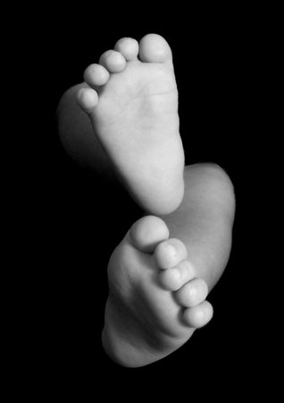 Newborn baby feet in a black backgorund
