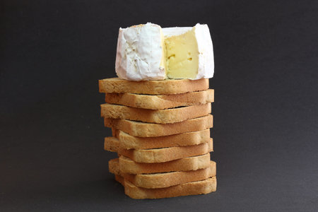 Cheese on a pile of toasts in a black background