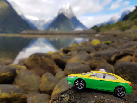 Model car on the stone behind a mountain view with snow cover.That seems to be driven on a hill.の写真素材